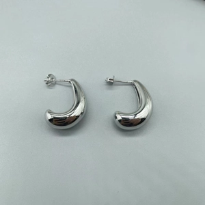 Detailed top view of minimalist silver C-shape hoop earrings with mirror finish