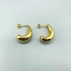 Detail view of mirror-polished gold-plated teardrop stud earrings with butterfly backs