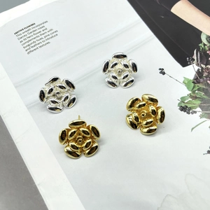Detailed view of layered camellia flower earrings in polished gold and silver finishes
