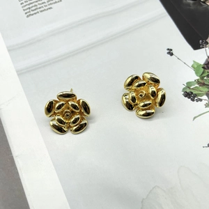 Close-up of 18K gold plated camellia stud earrings with layered metallic petals