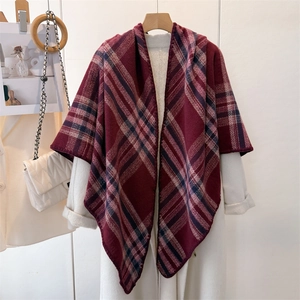 Detailed texture of red and blue plaid cashmere-like shawl draped over a white wool coat