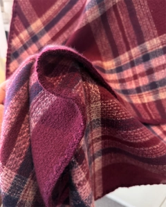 Close-up of the thick brushed cashmere-like fabric with deep red and purple plaid pattern