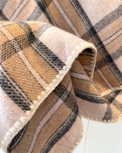 Close-up of classic beige plaid scarf showing soft cashmere-like texture and edge stitching