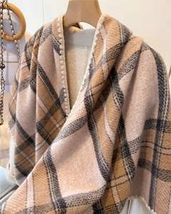 Detailed view of warm camel plaid shawl with thick knit fabric and soft white faux fur lining