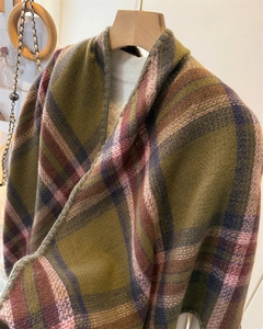 Detailed texture of plaid cashmere-like scarf with fringe edges in olive and purple