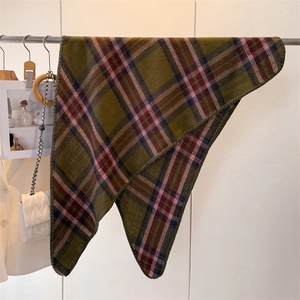 Close-up of olive green plaid scarf with soft cashmere texture hanging in a boutique