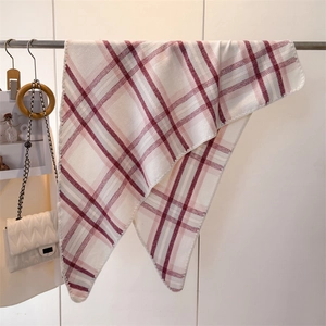 Close-up of red and white checkered scarf texture with fine stitched edge detailing