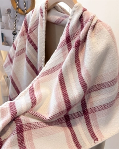 Detailed texture of a soft pink and white plaid cashmere-like triangle shawl scarf