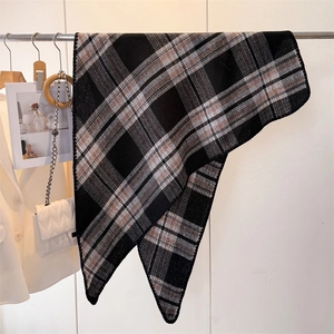 Detail of plaid faux cashmere triangular scarf with knitted texture and hemmed edges