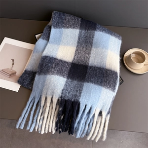 Détail d'une écharpe à carreaux bleus et noirs avec de larges franges et maille douce
