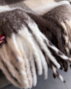 Détail d'une écharpe à carreaux épaisse avec texture pelucheuse et bords à franges