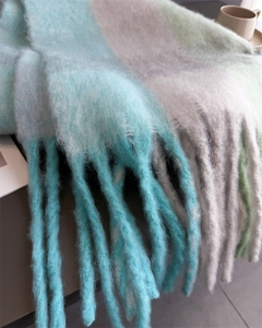 Détail de l'écharpe à carreaux arc-en-ciel avec franges longues et texture duveteuse