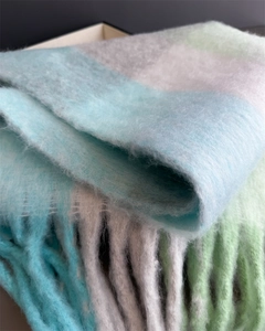 Gros plan sur la texture d'une écharpe à carreaux pastel avec de longues franges