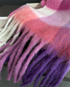 Détail d'une écharpe à carreaux colorés avec longues franges et texture douce
