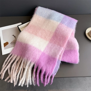 Détail d'une écharpe à carreaux pastel doux avec texture brossée et longues franges