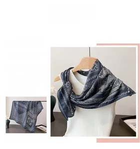 Detail of elegant navy blue paisley silk scarf draped over a wooden hanger