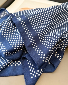 Detailed close-up of dark blue polka dot scarf showing fine twill weave fabric texture