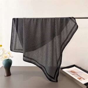 Polka dot herringbone pattern scarf hanging on a rack with floral decor for elegant look