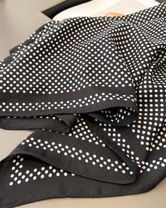 Detail of black silk scarf with white polka dots and premium twill weaving texture