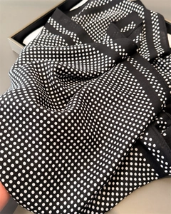 Detailed view of the black and white polka dot pattern on soft silk feel fabric
