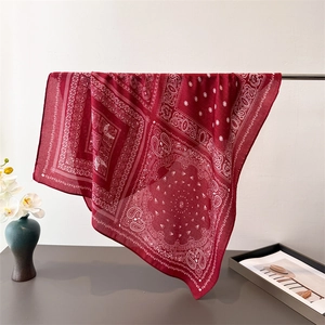 Red paisley print square scarf in lightweight cotton-linen hanging on a metal stand