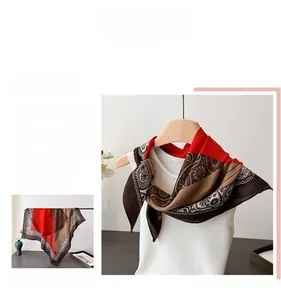 Detail of red and brown paisley silk scarf with vintage floral border and glossy texture