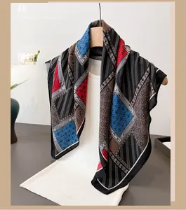 Detail of paisley and herringbone pattern cotton linen scarf hanging on a wooden hanger