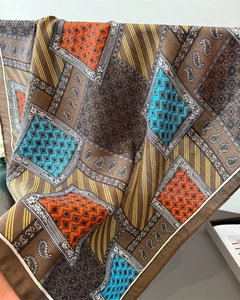Detail of vintage paisley and geometric pattern silk scarf with earth tones and vibrant accents