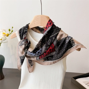 Detail of silk-texture paisley and geometric print scarf with premium beige hem edges