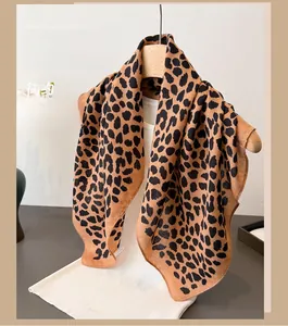 Detail of leopard print long scarf with classic brown and black spots hanging on hanger