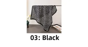 Detail of black and white leopard print square scarf hanging on a metal rack display