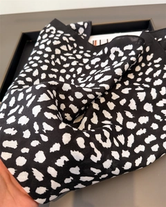 Detail of a lightweight black and white leopard print silk scarf with a wide black border