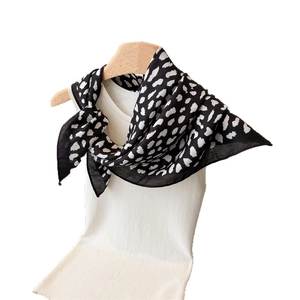Leopard print silk scarf for women styled on a white vest with a wooden hanger