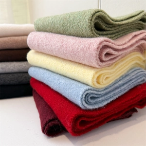 Close-up of stacked colorful knit scarves showing soft texture and premium stitching