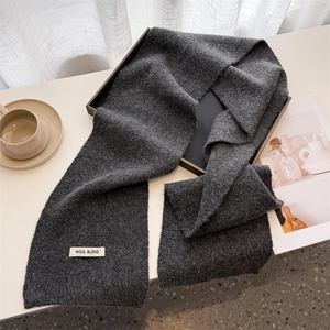Detailed view of dark grey wool blend knitted scarf texture and warm fabric finish