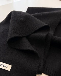 Detail of black knit scarf featuring a minimalist BLEND brand woven label and fuzzy texture