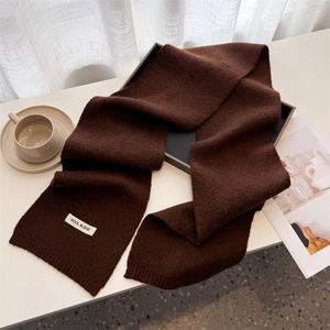 Close-up of dark brown wool blend knit scarf with ribbed texture and soft finish