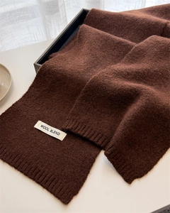 Detailed view of dark brown wool blend knitted scarf with premium ribbed edges