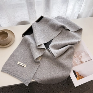 Close-up of grey wool blend knitted scarf texture with premium material tag