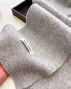 Detailed macro view of the wool blend knitted texture and ribbed edge of this grey scarf