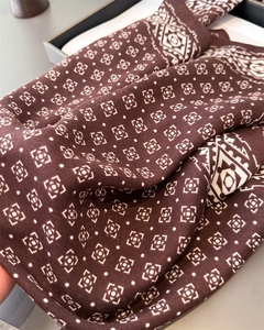 Vue macro d'un foulard en soie avec motifs géométriques et bordure ethnique