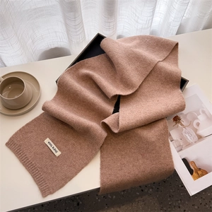 Close-up of a cozy camel knit wool blend scarf with ribbed edges in a winter setting