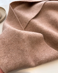 Macro shot of high-quality dusty pink cashmere knit fabric showing soft fuzzy texture