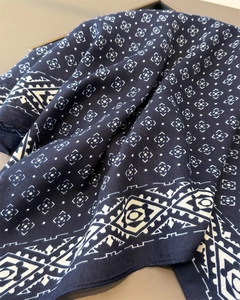 Gros plan détaillé du motif géométrique sur foulard bleu marine avec bordure ethnique