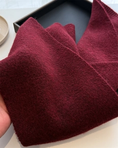 Detailed texture of dark burgundy knit scarf with premium soft wool material and stitching