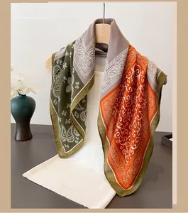 Detail of paisley pattern cotton-linen scarf draped on a white vest and wooden hanger