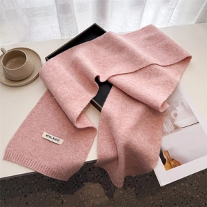 Detailed close-up of wool blend knit scarf texture with authentic product label
