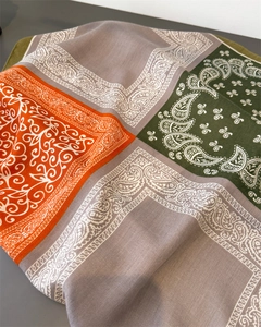 Detailed view of the multi-colored paisley pattern and twill fabric texture on the scarf