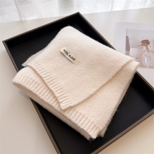 Close-up of soft off-white wool blend knitted scarf with textured ribbing details