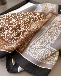 Close-up of paisley pattern and herringbone texture on a soft silk-feel square scarf